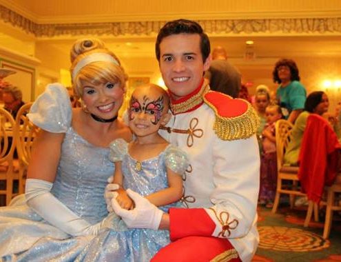 two actors dressed as cinderella and prince charming with a child